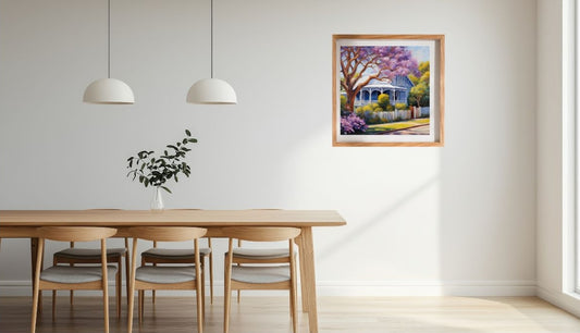 Dining room with wooden table, chairs, and a framed Australian weatherboard californian bunglaow painting on the wall.