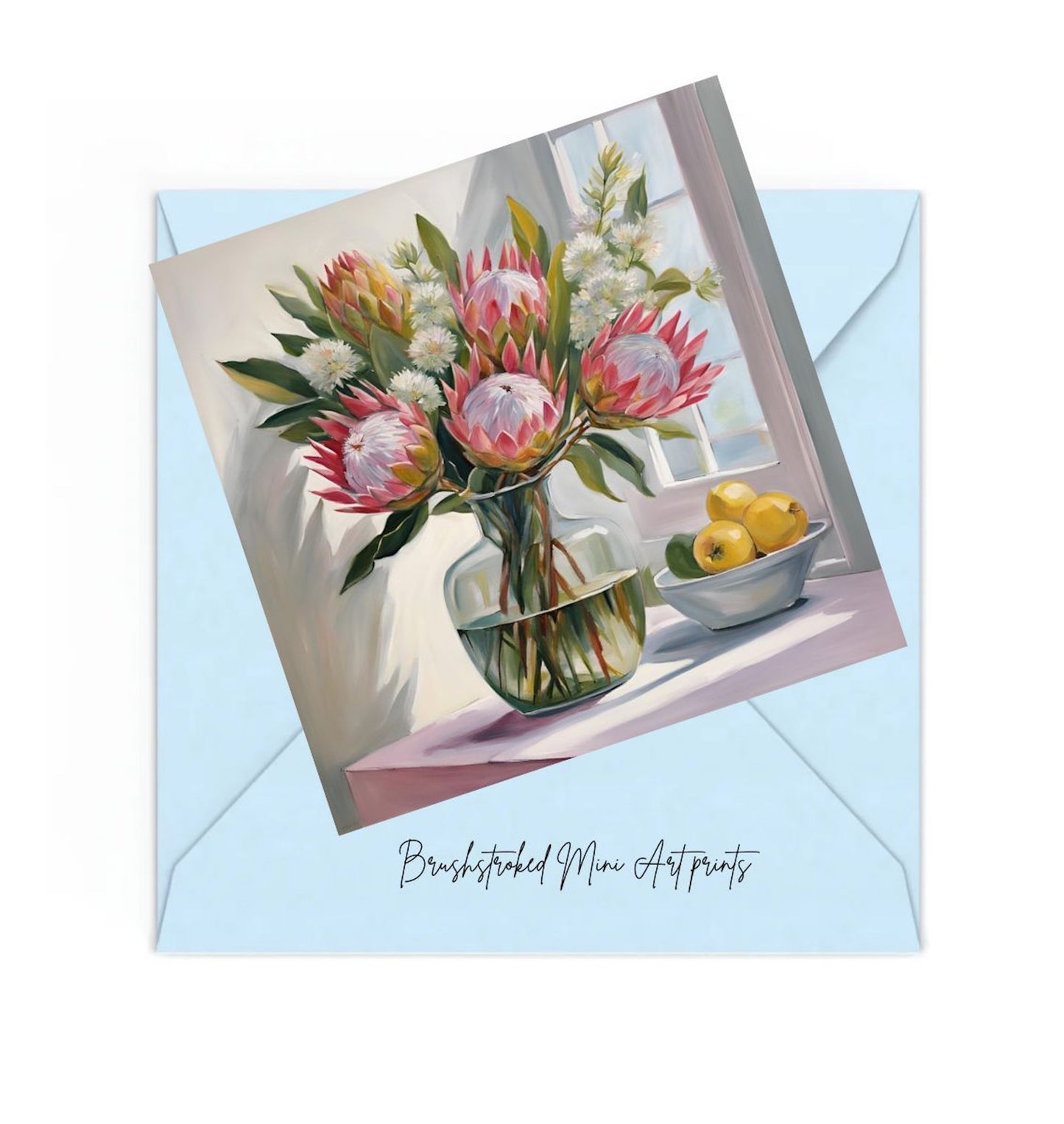 mini art print of pink proteas and lemons on table near window, on top of a blue envelope