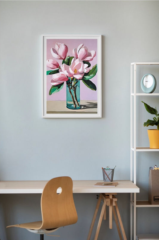 pink magnolia flowers in blue glass vase on table art print framed in white and hung above desk on the wall.on wall