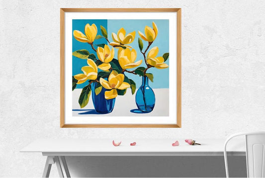 yellow flowers in blue vases on table art print framed in wood hanging on wall above white desk.