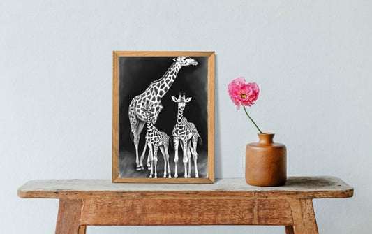 black and white giraffes art print in frame sitting on table