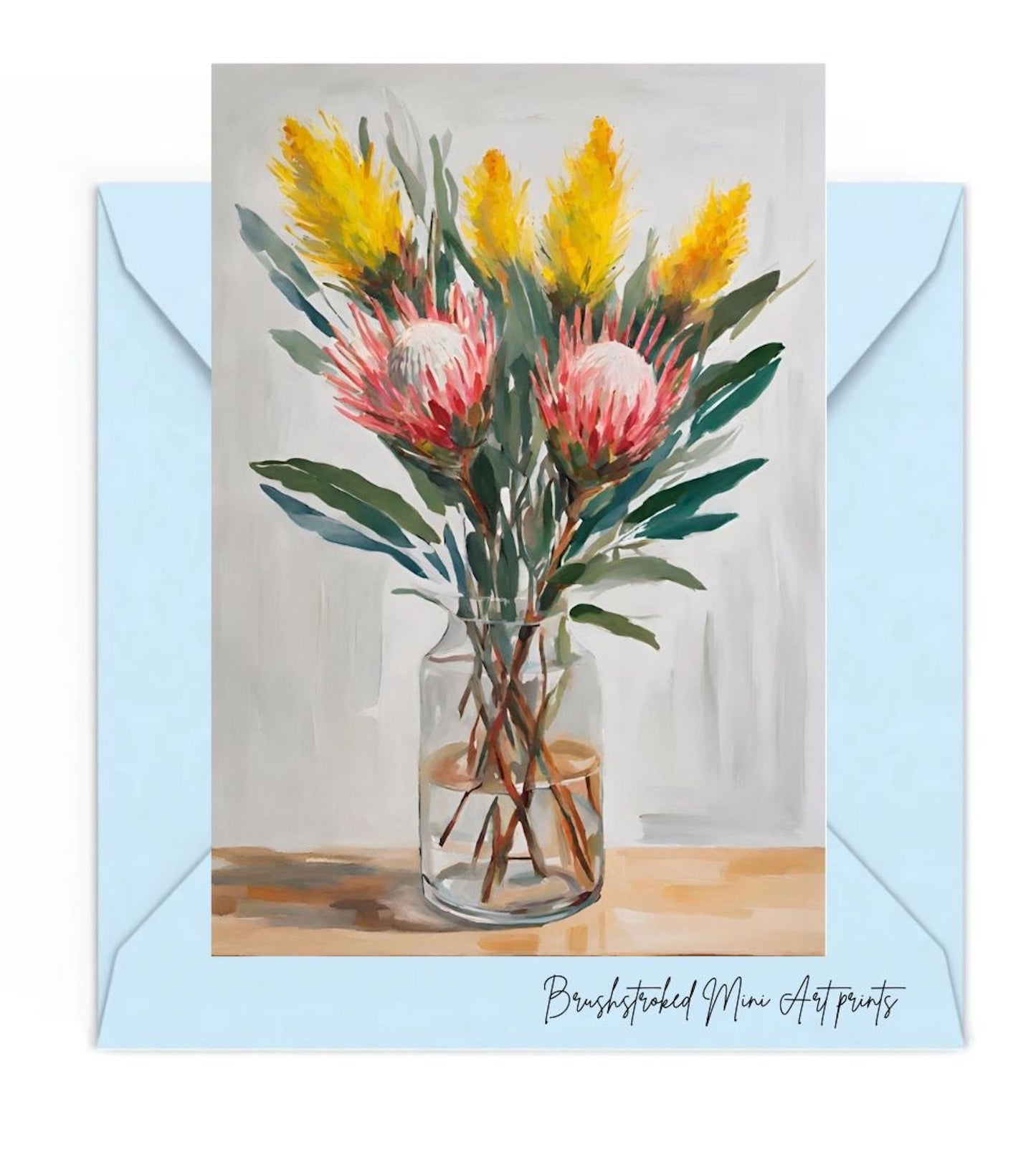 australian native flowers yellow wattle and pink proteas and green leaves in glass vase on table mini art print on blue envelope
