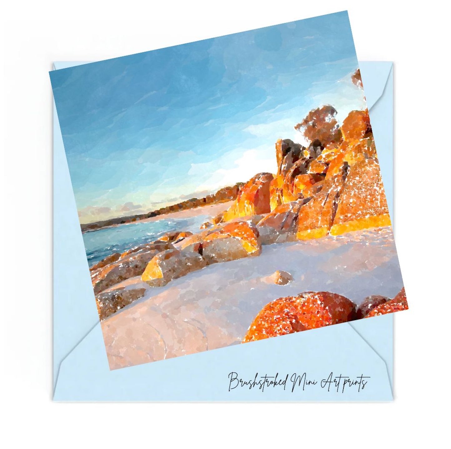 mini art print of bay of fires in tasmania blue skies red rocks white sand on top of a blue envelope