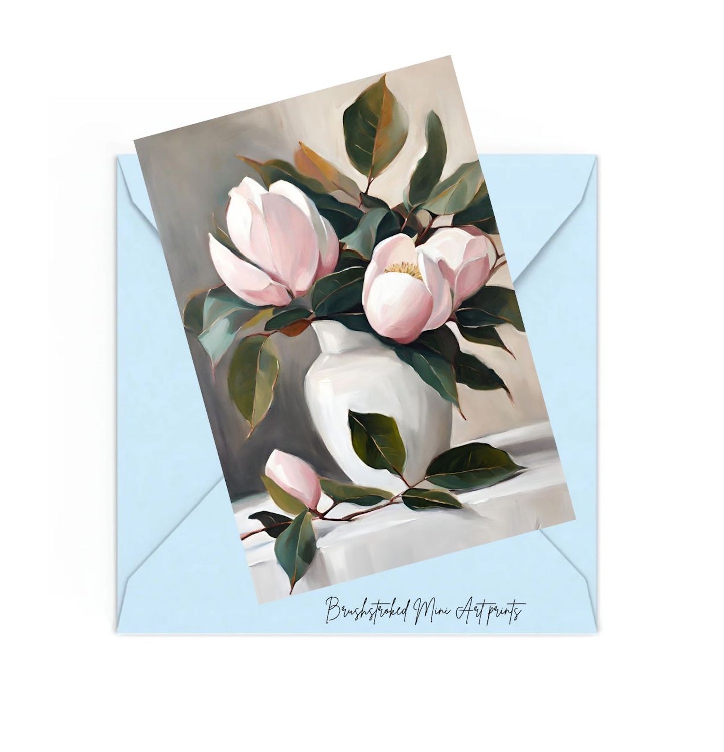 light pink magnolias with green in white eramic vase on table mini art print