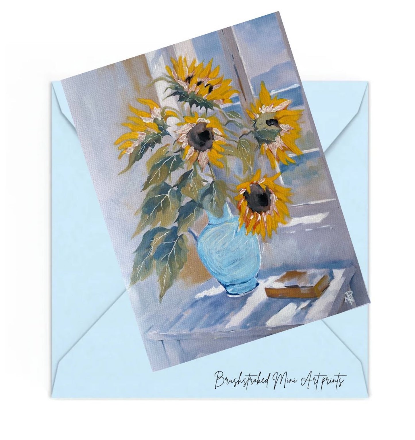 yellow sunflowers in blue vase on table near window mini art print.