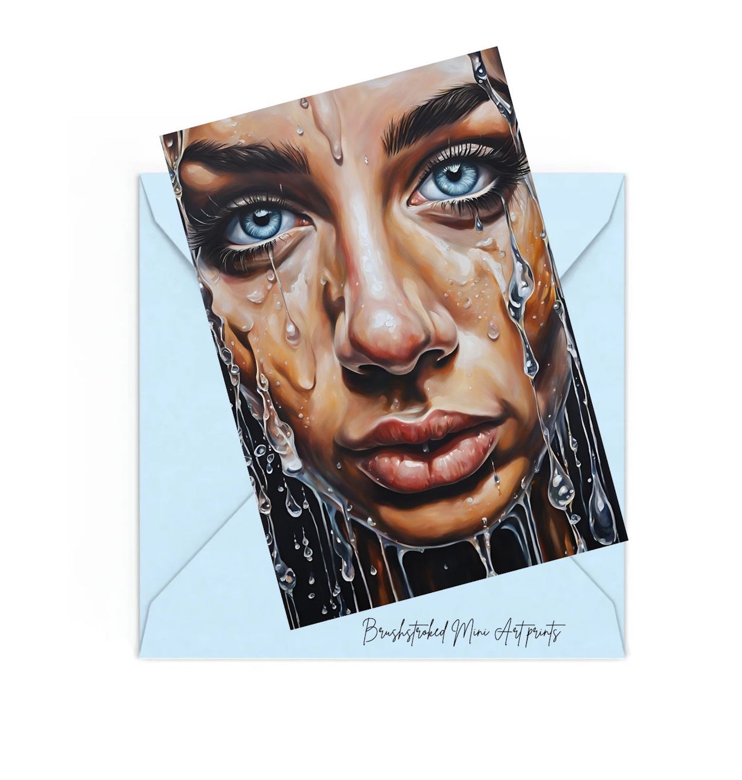mini art print of a woman with blue eyeys, on top of a blue envelope