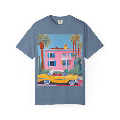 Blue t shirt printed on the front with a colourful palm springs pink house and a yellow vintage car and palm trees.