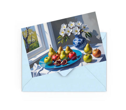 Mini still life art print of flowers and fruit on table, on top of a blue envelope for posting.