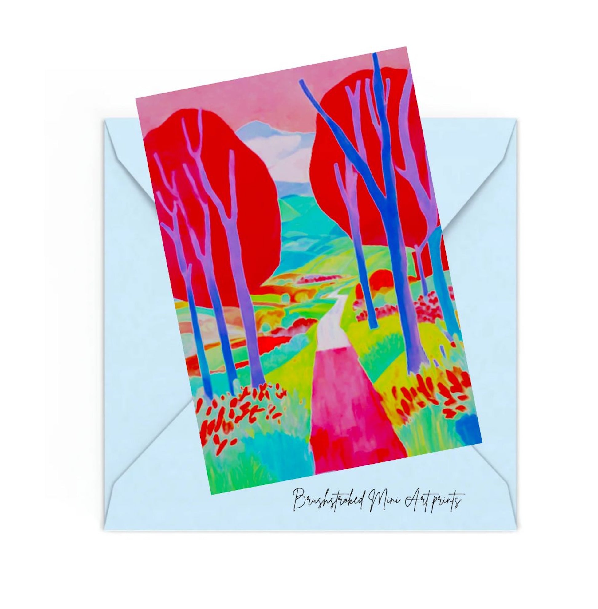 mini art print with Pink trees path and hills on top of an envelope