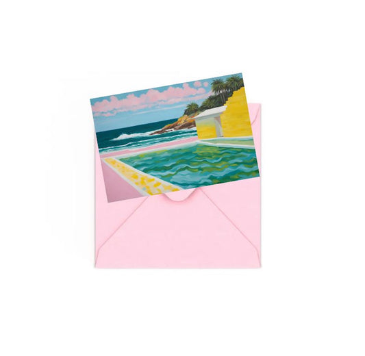 Mini art print of a seascape with a colourful house and pool and palm trees on top of a Pink envelope