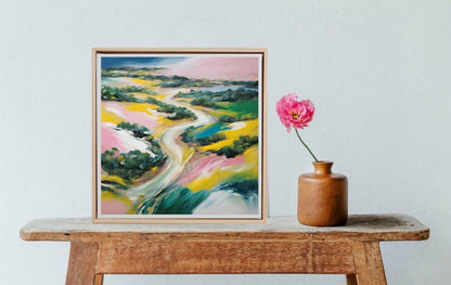 abstract colourful landscape art in frame on table