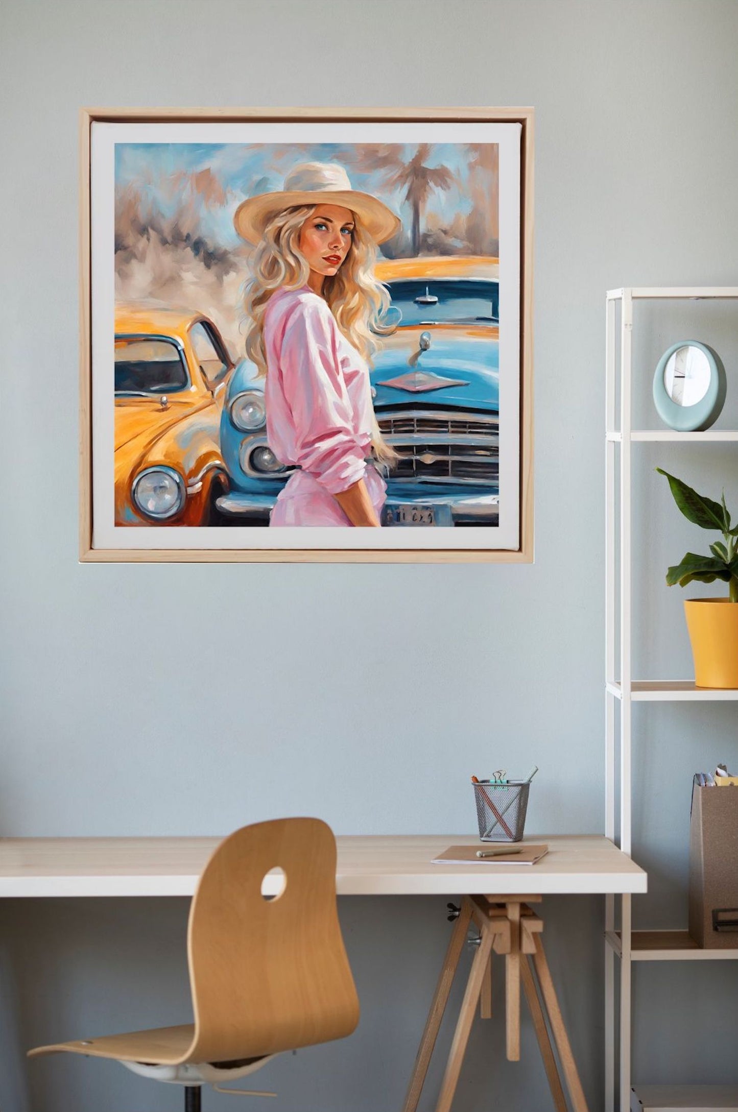 blonde woman in straw hat wearing a pink dress standing near vintage cars art print framed in wood and hanging on wall.