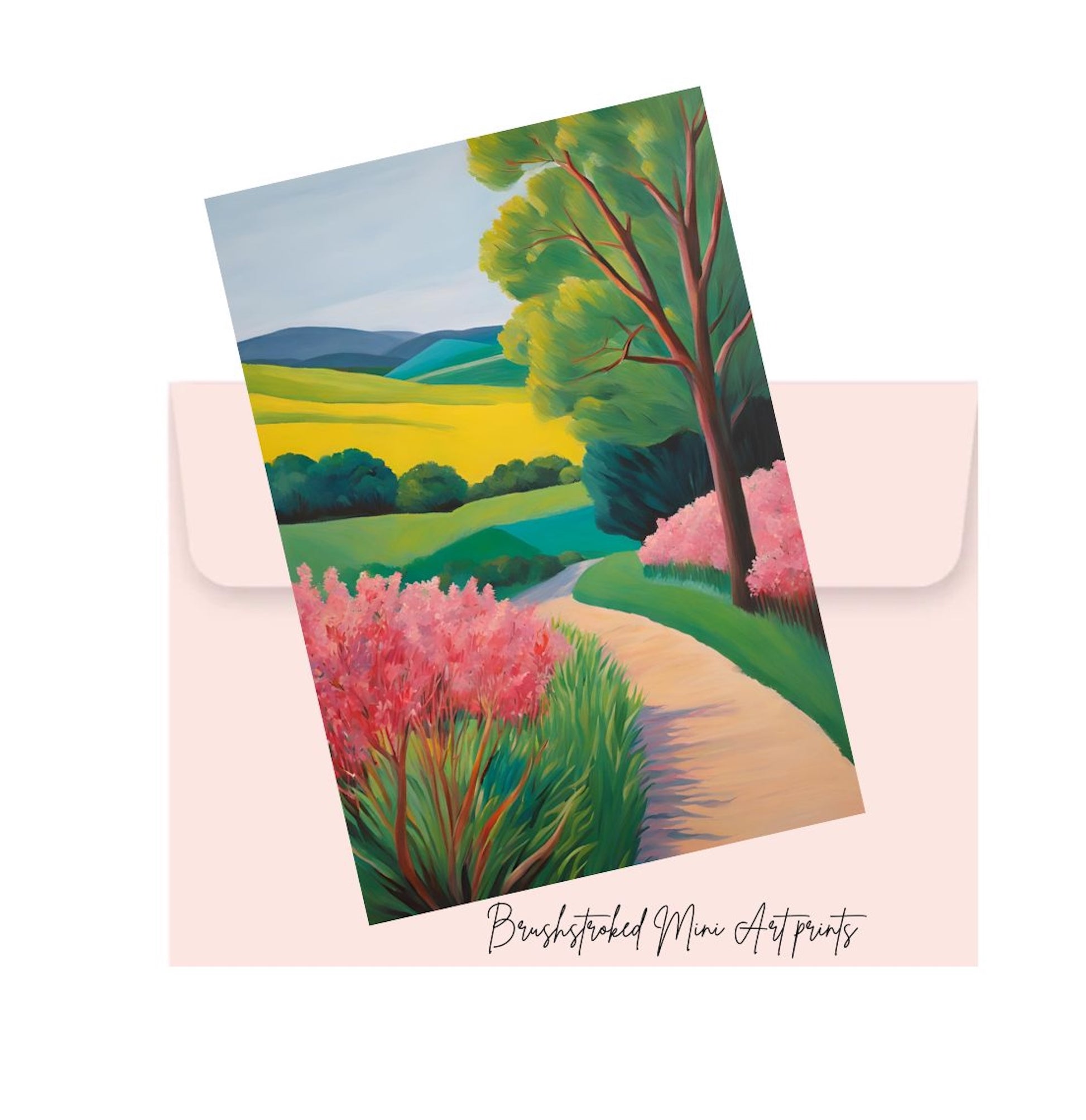 Landscape mini print with pink flowers and green trees  hills and a path on top of a pink envelope, featuring 'Brushstroked mini Art Prints' branding.
