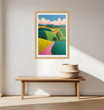 Framed artwork of a colorful  abstract landscape on a wall above a wooden bench.