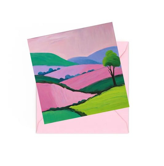 Mini art print of a colourful landscape with tree, hills, sitting on top of a Pink envelope.
