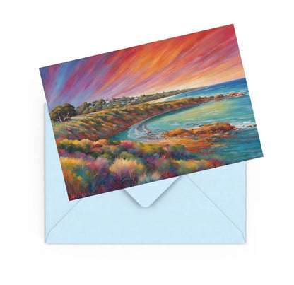 mini art print of a colourful sunset over the sea, on top of a Blue envelope for posting.