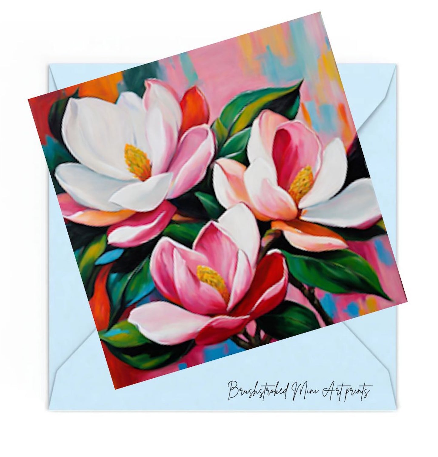 pink magnolias and green leaves on a coloiurful background mini art print on a blue envelope.