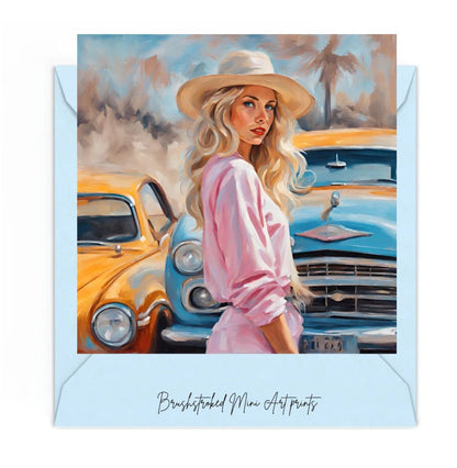 woman wearing pink dress and wearing a straw hat in front of two vintage cars mini art print